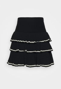 Černá sukna ve vrstveném stylu s ribbovanou texturou, která má tři volánkové vrstvy. Okraje jsou lemovány kontrastní bílou šňůrkou. Elastický pas.