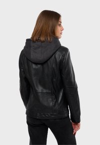 Crna kožna jakna s sivim duksericom, s rebrastim detaljima na ramenima i rukavima, glatkom teksturom i prilagođenim dizajnom.