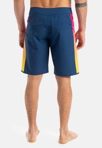 Męskie kąpielówki, granatowe z gradientowym wzorem z różowymi i żółtymi akcentami. Wykonane z lekkiego materiału, z przeszytymi szwami i kieszenią z tyłu.