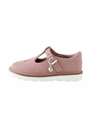Pink suede Mary Jane shoe with silver heart charm on buckle, white ridged sole, and perforated toe detail, shown in side view.