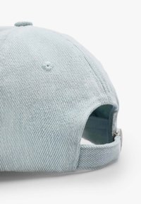 Jasnoniebieska czapka z denimu o zaokrąglonej koronie, widocznych szwach i regulowanym pasku z tyłu. Teksturowany materiał o swobodnym designie.