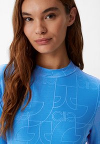 Maglietta blu a maniche lunghe con un motivo logo geometrico testurizzato. Tessuto liscio con un design aderente e collo alto.