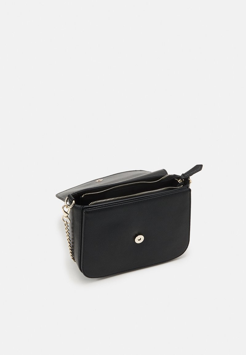Bolso de hombro de cuero negro con un acabado texturizado, que cuenta con un cierre con cremallera, una correa de cadena y un detalle de botón de presión en la parte delantera.