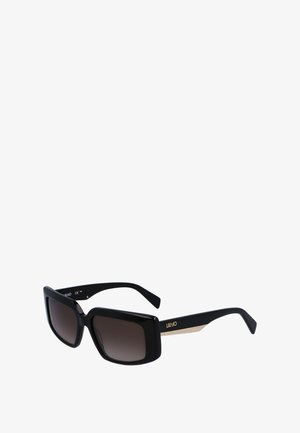 Black oversized sunglasses with gradient brown lenses, featuring textured gold-accented arms. The design is squared with a glossy finish.