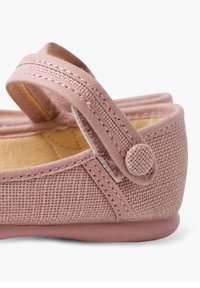 Chaussure en tissu rose avec une finition texturée. Dotée d'un bout arrondi, d'une sangle ajustable et d'une semelle en caoutchouc. Design léger et coutures simples.