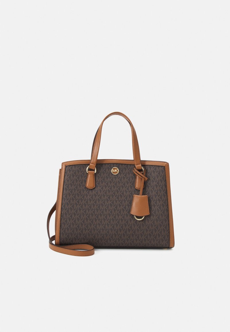 Brun monogram tote taske med lysebrune læderdetaljer, dobbelte top håndtag, aftagelig skulderrem og et guld logo emblem foran.