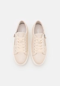 Et par beige lædersneakers med snørebånd og sidelukninger, vist ovenfra på en hvid baggrund.