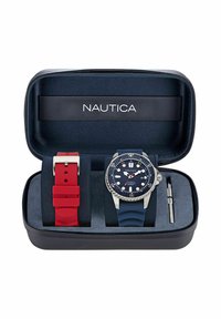 Nautica óra fekete cipzáras tokban, kék szilikon pántos órával, piros gumipánttal és szíjcserélő szerszámmal.