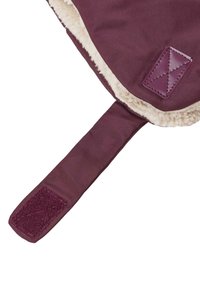 Plysset burgunder stof med en plysset hvid foring, der har en tekstureret lap og en flad rem med en velcro-lukning.