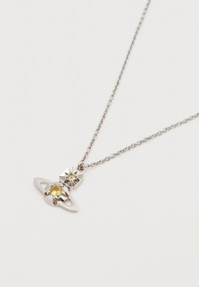 Ασημένιο κολιέ με μενταγιόν σε σχήμα πλανήτη με κίτρινες πολύτιμες πέτρες, που περιλαμβάνει μια μεγαλύτερη κεντρική πέτρα και μικρότερες πέτρες στολισμού.