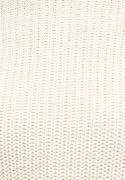 Κοντινή λήψη κρεμ υφαντού υφάσματος με υφασμένο ριμπ μοτίβο σε κάθετες σειρές.