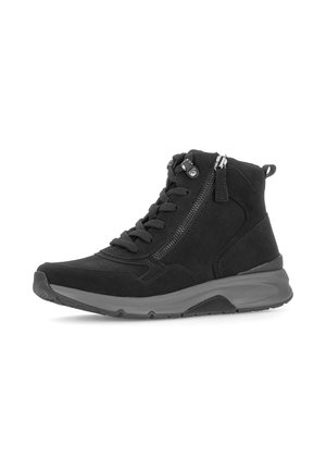 Zwarte hoge sneaker met dikke grijze zool, zijrits en veters, van opzij gezien op een witte achtergrond.