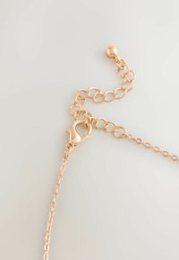 Guldfarvet kædearmbånd med en hummerlås, der har sammenkædede runde led og en glat, poleret overflade; justerbar længde.