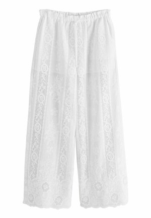 Białe spodnie o szerokich nogawkach z pionowymi koronkowymi kwiatowymi panelami i falowanymi brzegami, z elastycznym pasem i przednim sznurkiem.