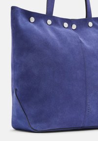 Niebieska skórzana torba tote z srebrnymi zapięciami, z fakturowanym wykończeniem, solidnymi uchwytami oraz detalem szwu bocznego.
