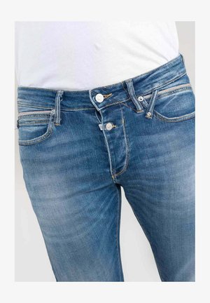 Blauwe spijkerbroek met een klassieke pasvorm, voorzien van een rits en knoopsluiting, vijf zakken en subtiele vervaging voor textuur.