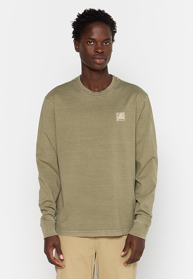 Olivgrön långärmad t-shirt i mjuk bomull med en liten fyrkantig logotyp på övre vänstra bröstet. Enkel, avslappnad passform.
