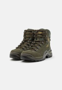 Wanderschuhe in Olivgrün mit einer strukturierten Veloursleder- und Synthetik-Oberfläche, verstärkter Zehenkappe, gelben und schwarzen Schnürsenkeln sowie einer robusten Gummisohle.