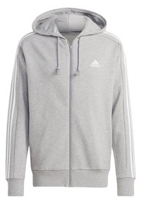 Felpa con cappuccio grigia con zip, realizzata in tessuto morbido, con cappuccio, dettagli bianchi a tre strisce sulle maniche e un logo ricamato sul petto.