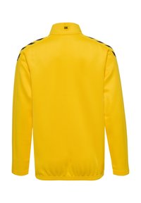 Gul jacka med hög krage, långa ärmar och svarta accentränder längs axlarna. Slät textur med elastisk nederkant och ärmöppningar.