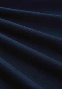 Dunkelblauer Stoff mit glatter Textur, in sanften Falten drapiert, der eine gleichmäßige Farbe und einen subtilen Glanz auf der Oberfläche zeigt.