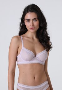 Reggiseno in pizzo lilla con coppe trasparenti, motivo floreale, spalline regolabili e bordi scallopati. Design delicato con texture morbida e un leggero luccichio.
