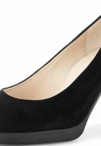 Escarpin en daim noir avec un bout rond et une plateforme. L'intérieur est beige, contrastant avec le matériau extérieur texturé.