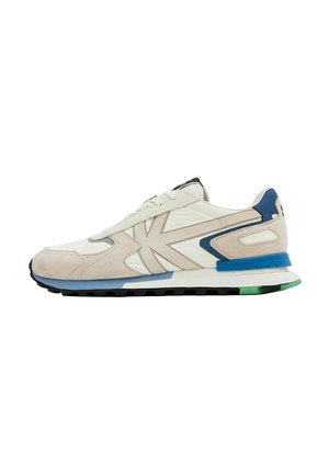 Beige and white sneaker with blue and green sole accents, beige suede overlays, and large beige side logo on a white background.