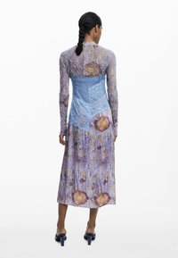 Vestido largo de flores con un corsé de encaje azul y fondo púrpura; presenta mangas largas y una falda fluida con patrones de flores.