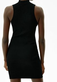 Abito nero a coste con collo alto, design senza maniche e silhouette aderente, che presenta una texture liscia e una forma avvolgente.