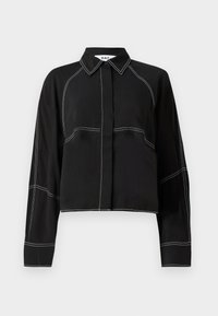Black cropped shirt with long sleeves, featuring white contrast stitching, a classic collar, and a button-down front design.