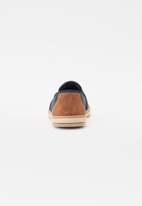 Scarpe slip-on in rete blu navy con tacco in suede beige, caratterizzate da un design testurizzato e una suola in corda naturale per un tocco di stile e dettaglio.
