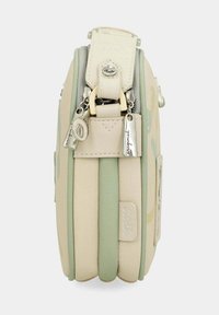 Bolso beige y verde menta con una superficie texturizada, que presenta herrajes metálicos y un tirador de cremallera decorativo. Forma delgada y rectangular.