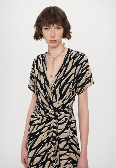 El vestido presenta un patrón abstracto en negro y beige, un diseño de escote en V, mangas cortas y una cintura atada, fabricado con un tejido suave.