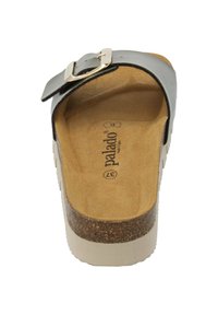 Zwarte leren slidesandalen met een kurken en witte plateauzool. Kenmerken een metalen gespsluiting en een tan suede binnenzool. Plat hak en open ontwerp.