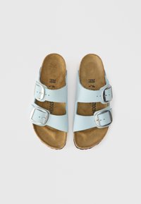 Ανοιχτό μπλε σανδάλια με δύο ρυθμιζόμενους ασημένιους γάντζους, μαλακό πέλμα από φελλό και ανατομικό σχήμα για άνεση. Ιδανικά για καθημερινές περιστάσεις.