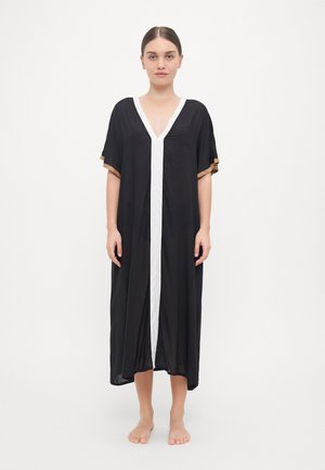 Black kaftan with a V-neck, white front panel, and short sleeves featuring gold accents. Lightweight, flowy material, floor-length design.