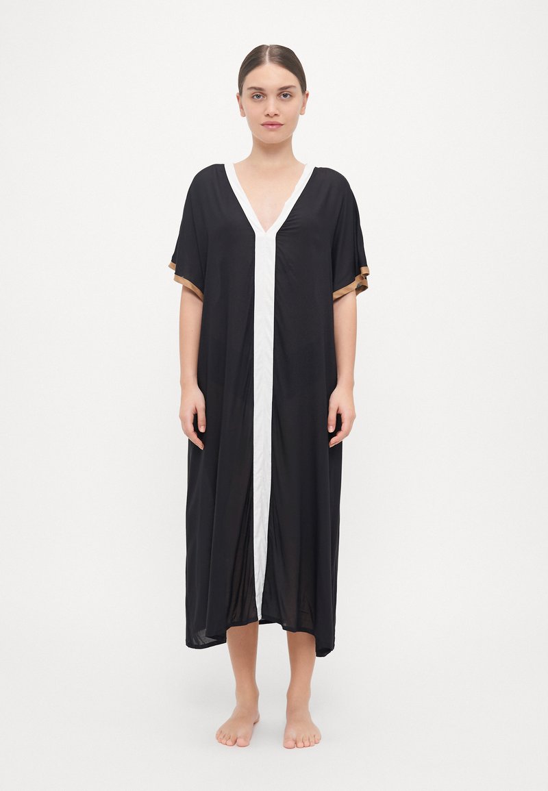 Črn kaftan z V-izrezom, belim sprednjim delom in kratkimi rokavi, okrašenimi z zlatimi detajli. Lahkotna, spuščena tkanina, dolžina do tal.