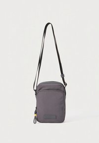 Kompakt mørkegrå crossbody-taske med justerbar rem, lynlåslomme foran og tekstureret stofoverflade med subtilt gittermønster.