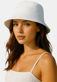 Witte emmerhoed met een gladde textuur, brede rand en verticale stikdetails. Gedragen met een lichtgekleurde top met dunne bandjes.