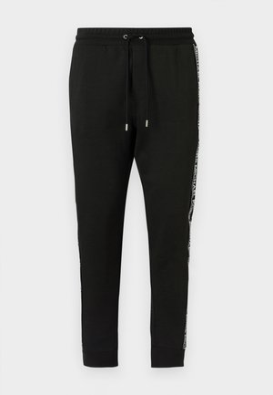 Fekete pamut melegítőnadrág húzózsinóros derékrésszel, oldalán csíkkal, logós díszítéssel és bordázott szegéllyel a bokáknál.