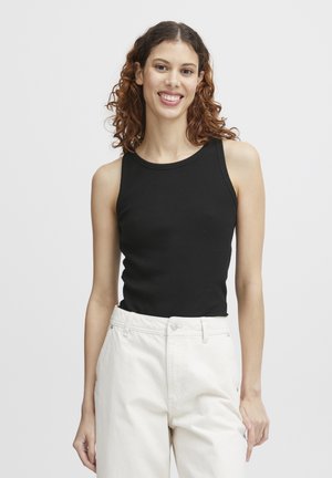 Schwarzes geripptes Tanktop mit rundem Halsausschnitt, kombiniert mit einer hoch taillierten, hellen Hose, vor einem schlichten weißen Hintergrund.