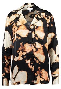 Svart och krämfärgad blus med ett vattendroppsmönster i beige, med en enda bröstficka och bruna knappar fram. Sidenliknande textur.