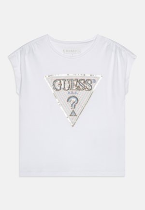T-shirt bianco a maniche corte in cotone biologico con logo "GUESS" triangolare in paillettes con accenti argentati e iridescenti.