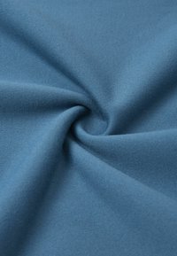 Tessuto blu con una texture liscia e uniforme, che presenta un motivo torciso. Il materiale sembra leggero e flessibile.