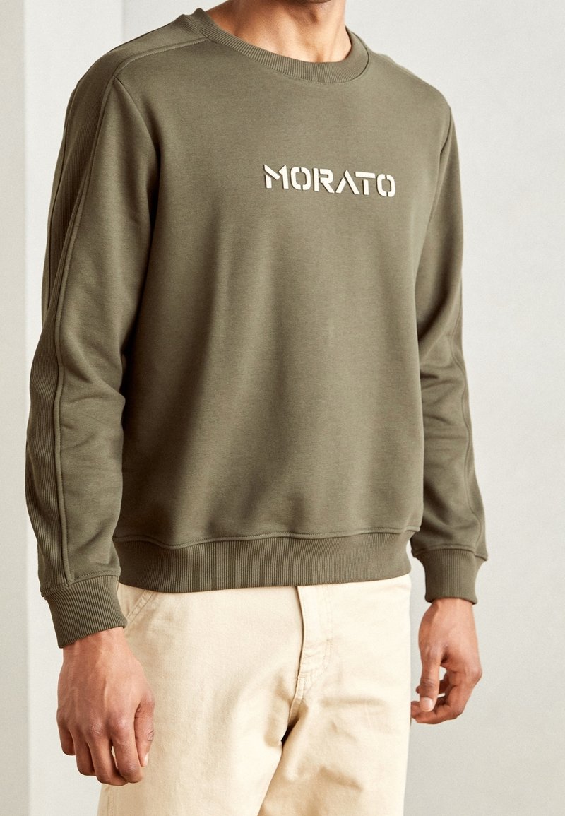 Olivgrön sweatshirt med ribbade muddar och nederkant, med ordet "MORATO" i vitt över bröstet, tillverkad av mjukt tyg.