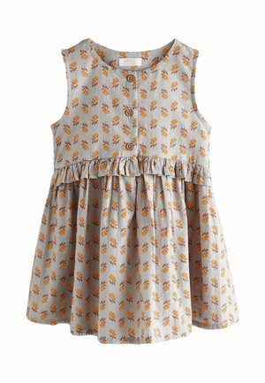 Sukienka w kwiatowy wzór w jasnoszarym kolorze, z pomarańczowymi kwiatowymi motywami. Posiada okrągły dekolt, bez rękawów i falbaniaste wykończenie u dołu. Drewniane guziki dekorują przód.