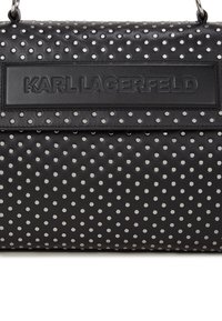 Fekete bőr kézitáska ezüst szegecselt pöttyökkel, texturált felülettel, és egy kiemelkedő logóval, amelyen az "KARL LAGERFELD" felirat van bemutatva.