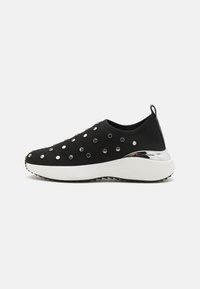 Fekete hálós sneaker ezüst fém részletekkel és fehér platform talppal. Simább felület és perforált részletek jellemzik.