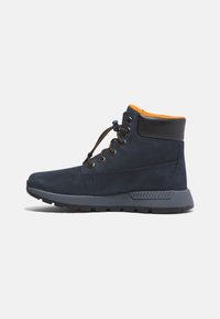 Granatowe buty trekkingowe z zamszową i siateczkową cholewką, pomarańczowym wnętrzem, okrągłymi sznurowadłami, metalowymi oczkami oraz wytrzymałą szaro-skalistą podeszwą z teksturowymi akcentami.